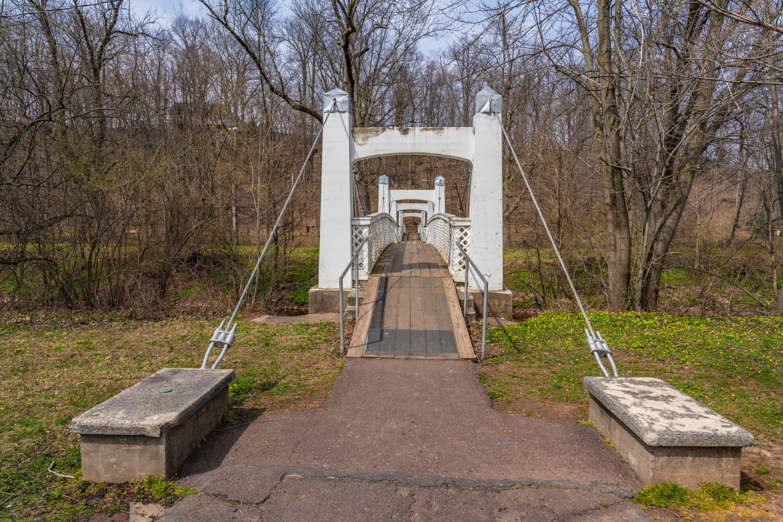 Wire suspension foot path bridge built in 1938 by the Works Progress Administration over the east branch of the Perkiomen Creek in Lenape Park in Perkasie, Bucks County Pennsylvania 
