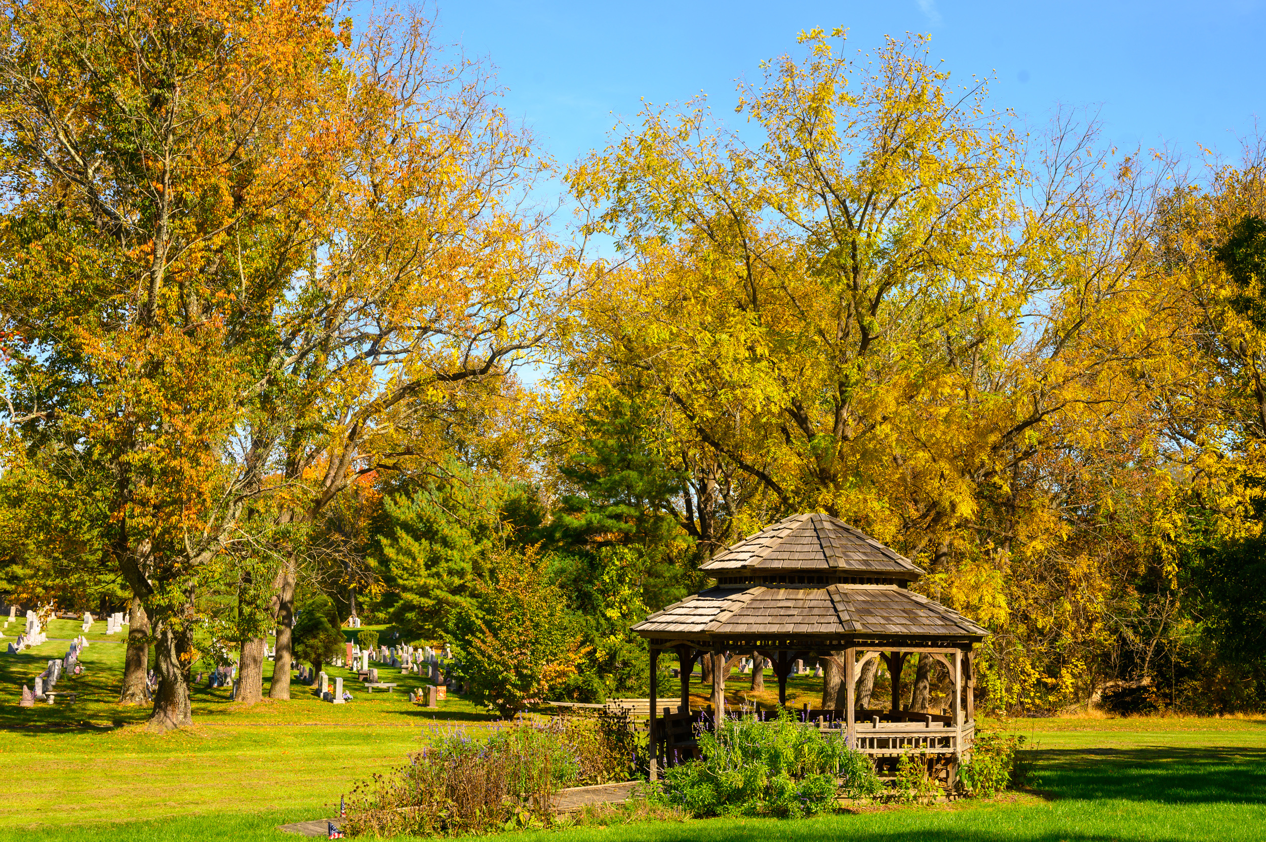 Autumn in Newtown, PA. Gazebo with cemetery in between trees in the background at Carl Sedia Park. Autumn in Newtown, PA. Gazebo with cemetery in between trees in the background at Carl Sedia Park.