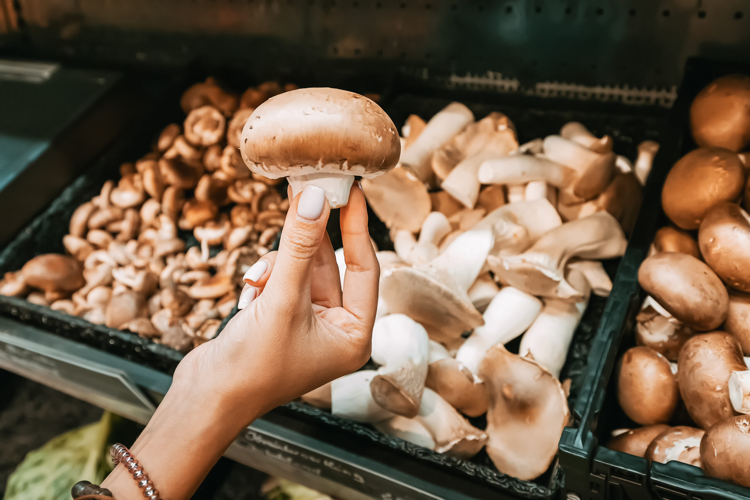 Woman holding up a mushroom she purchased in Kennett Square. 