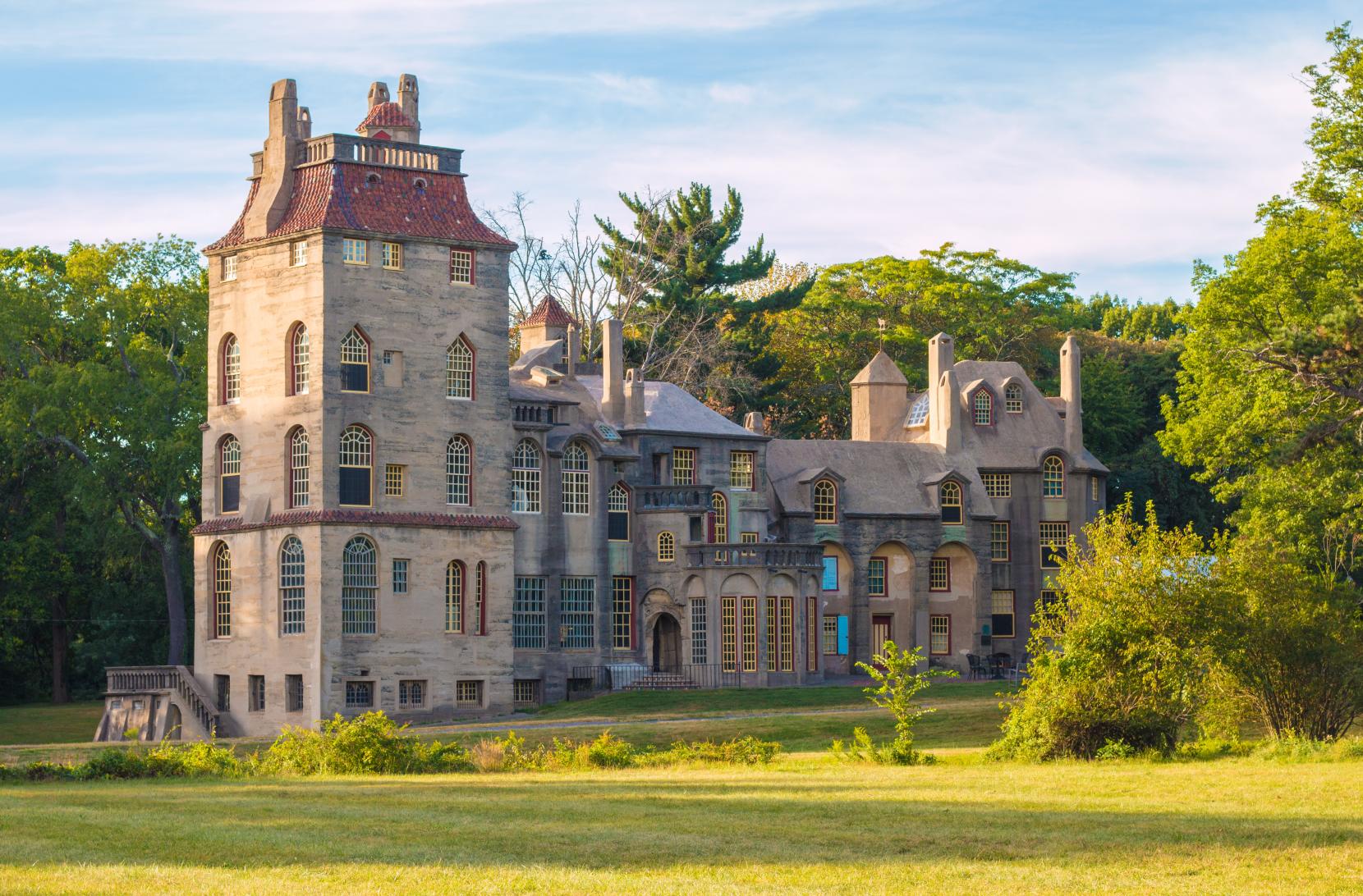 Historic Fonthill Castle in Doylestown, Pennsylvania, at twilight surrounded by trees and soft evening light 