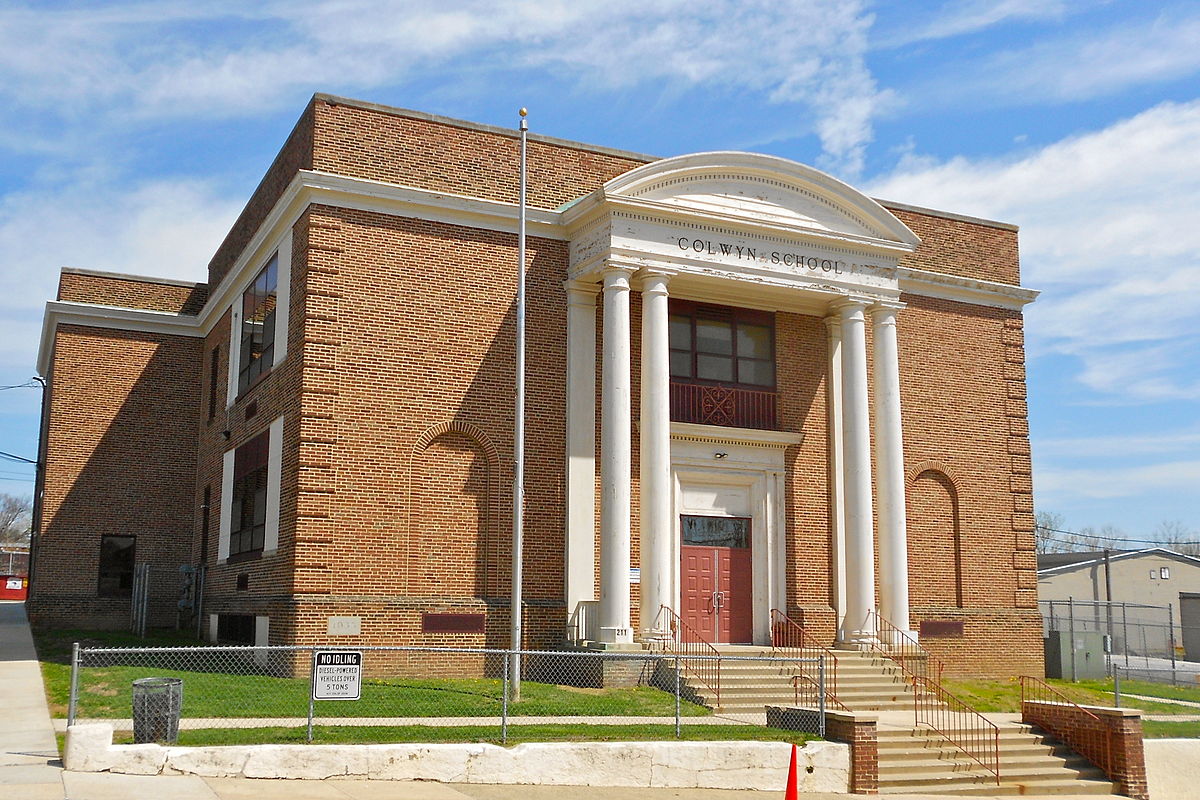 Front view of Colwyn Elementary School in Colwyn, PA surrounded by sidewalk and a well-kept lawn.