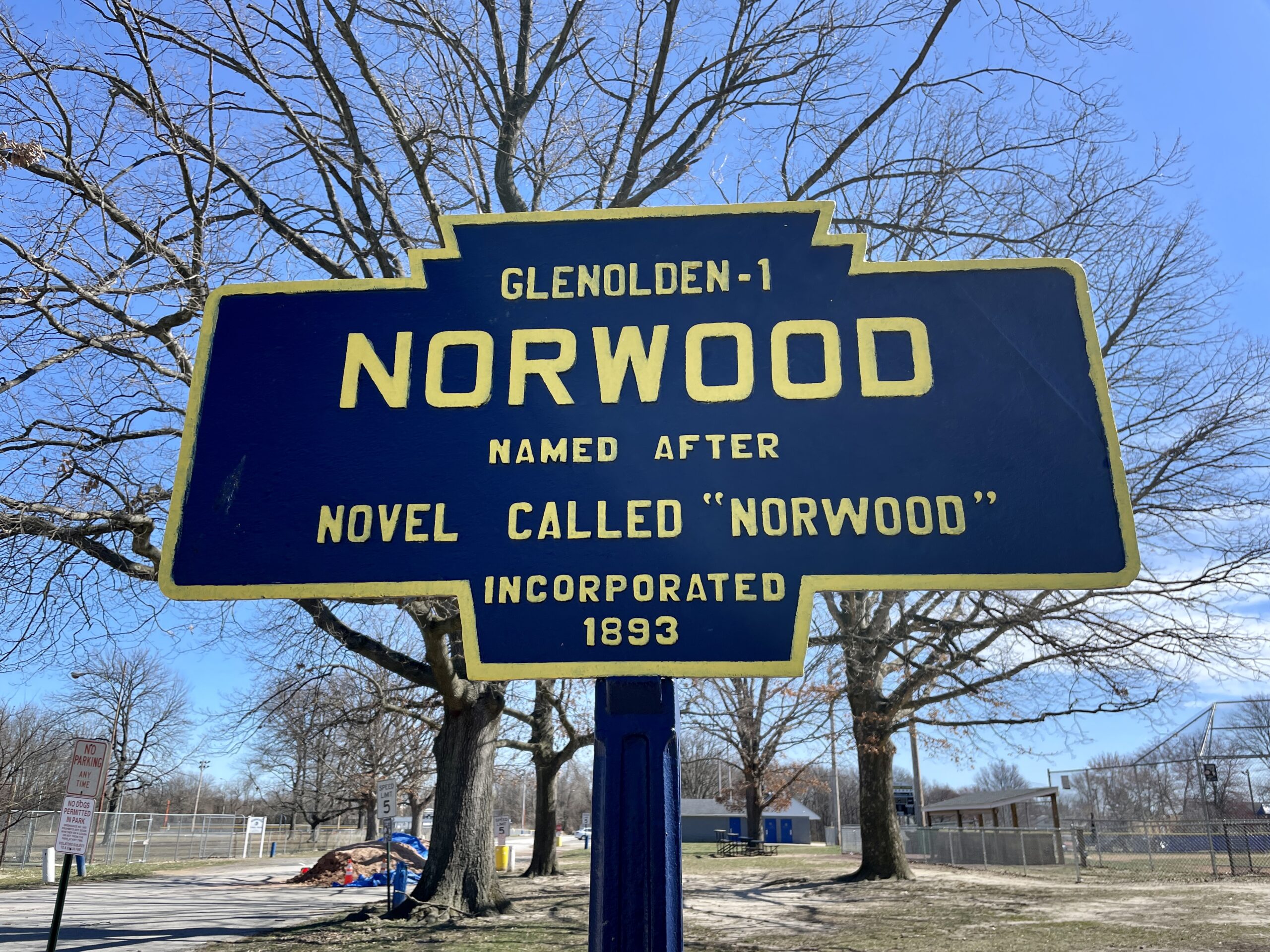 Blue and gold Pennsylvania keystone marker sign in a grassy park identifying the borough of Norwood, Pennsylvania.